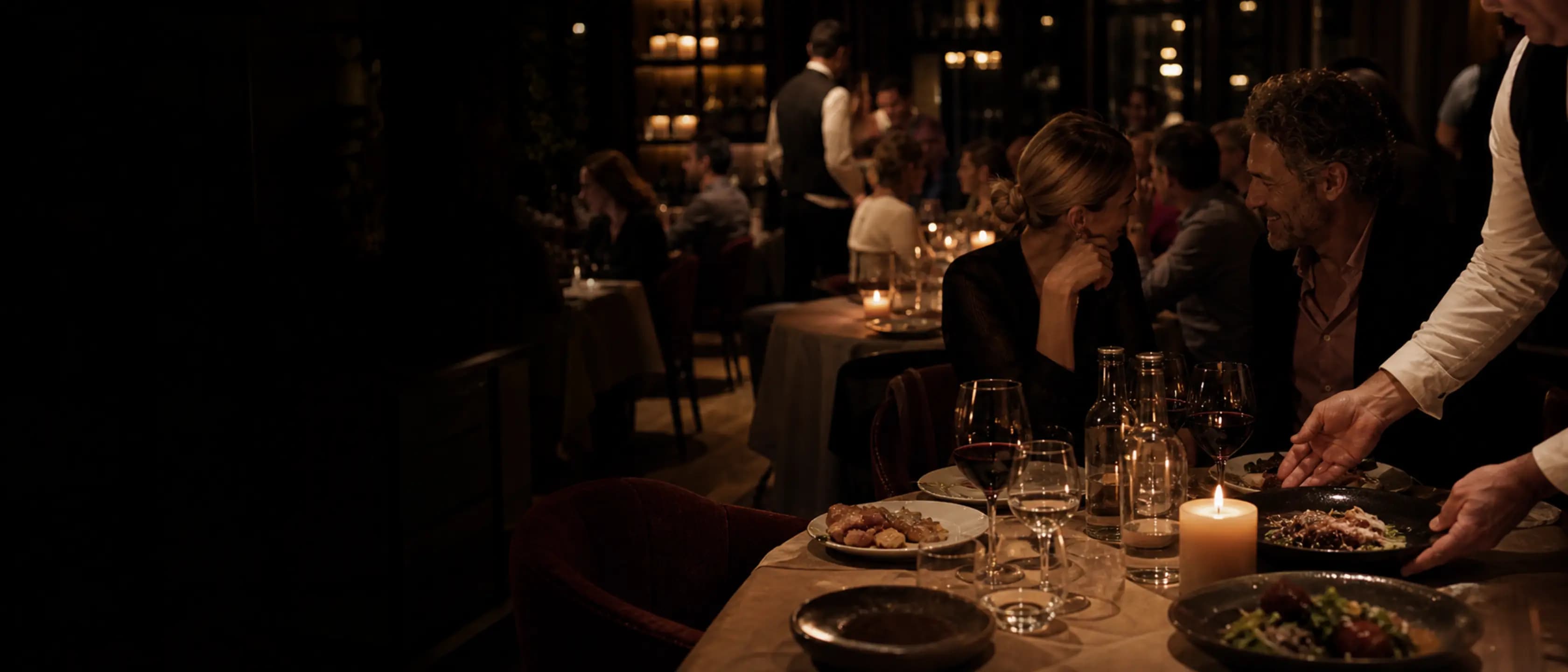 Abendlicher Restaurantservice mit gefüllten Tischen und Kerzenlicht
