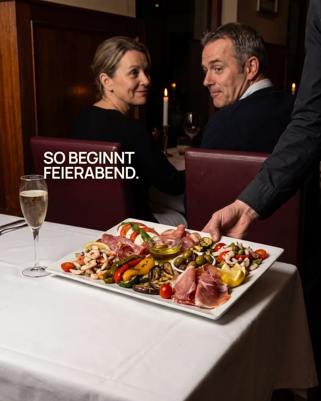 La-Commedia-Motiv mit Gästen am Tisch und einer großen Antipasti-Platte