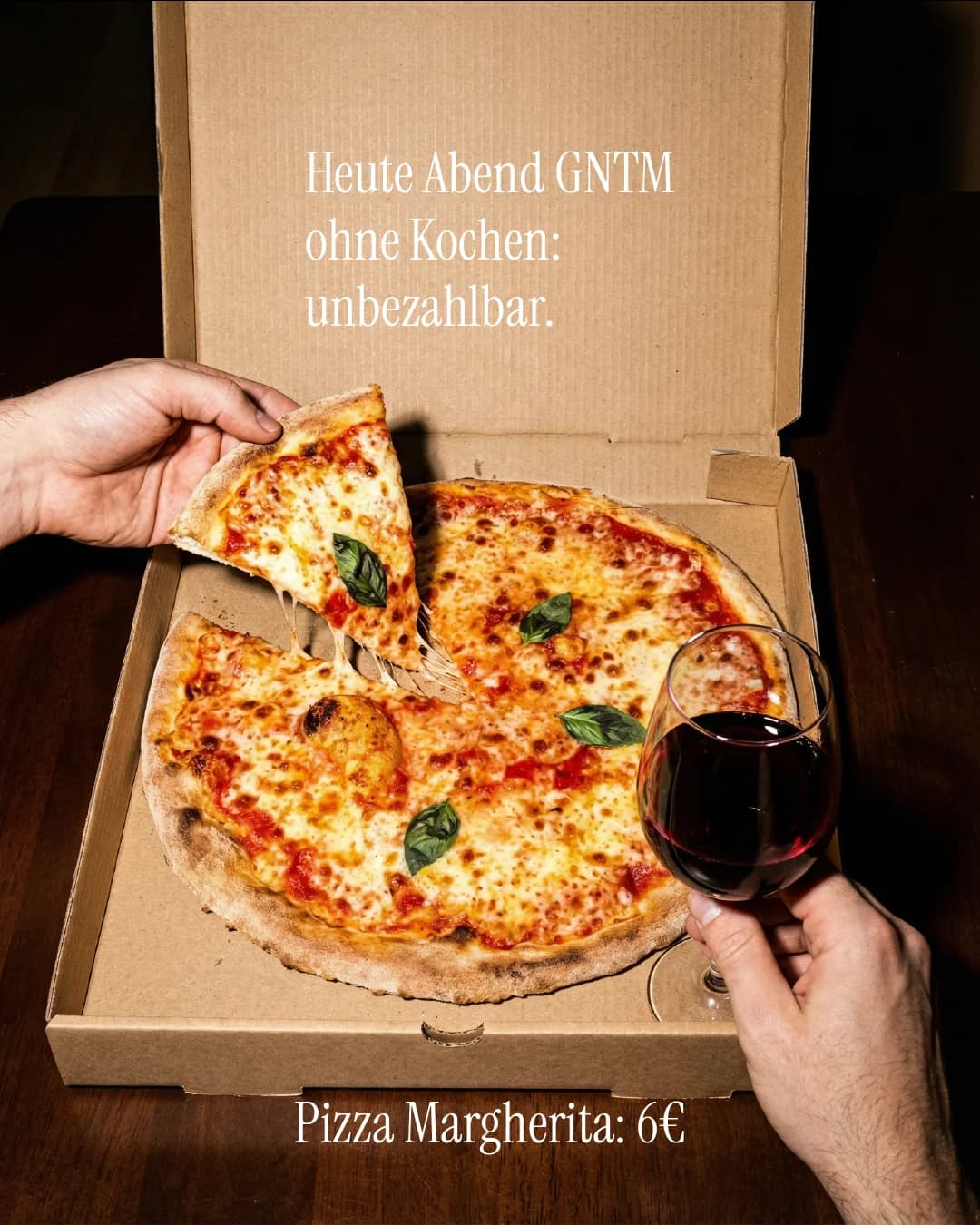 La-Commedia-Angebotsmotiv mit geöffneter Pizzaschachtel und Rotwein