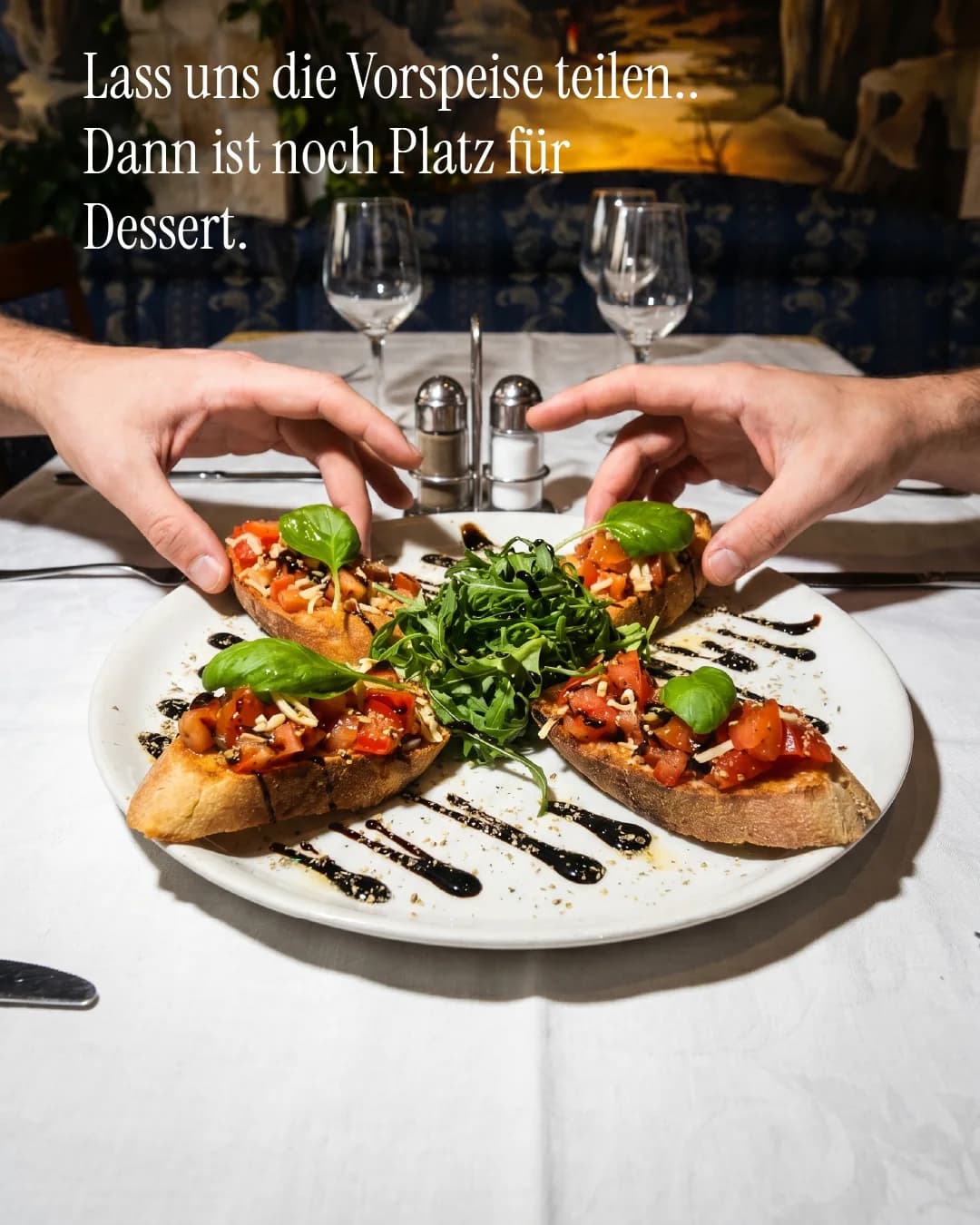 La-Commedia-Motiv mit zwei Händen über einer italienischen Vorspeise
